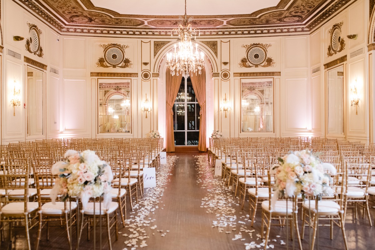 Wedding ceremony space with gold chairs and chandeliers