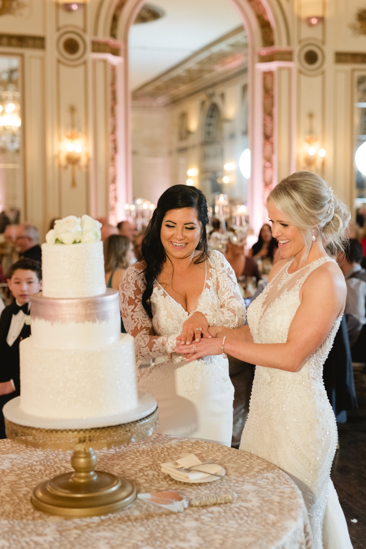 Two brides cutting wedding cake
