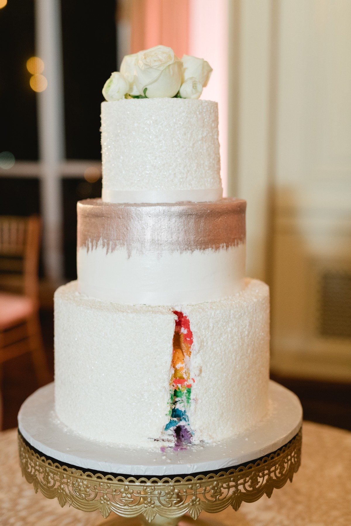 View of inside of cut wedding cake that is rainbow