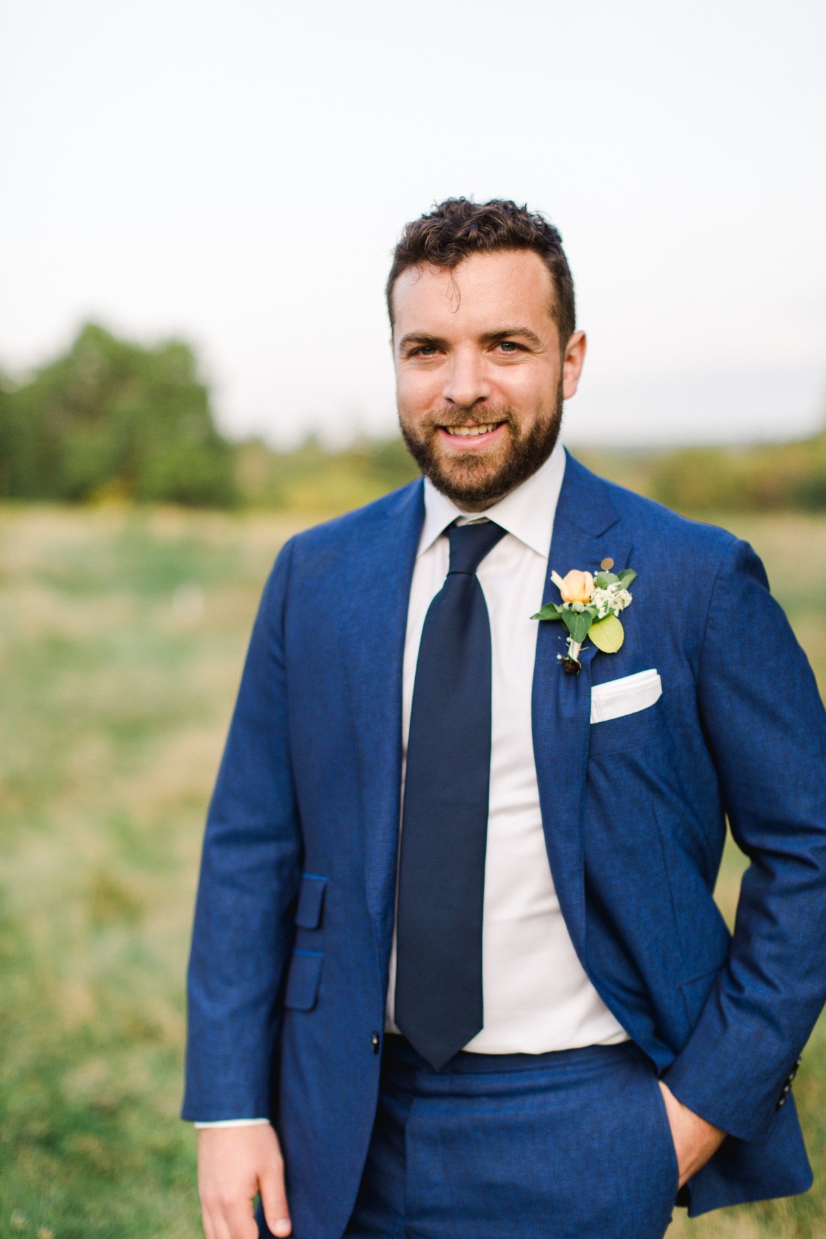 Portrait of groom in bright blue suit with boutonniere
