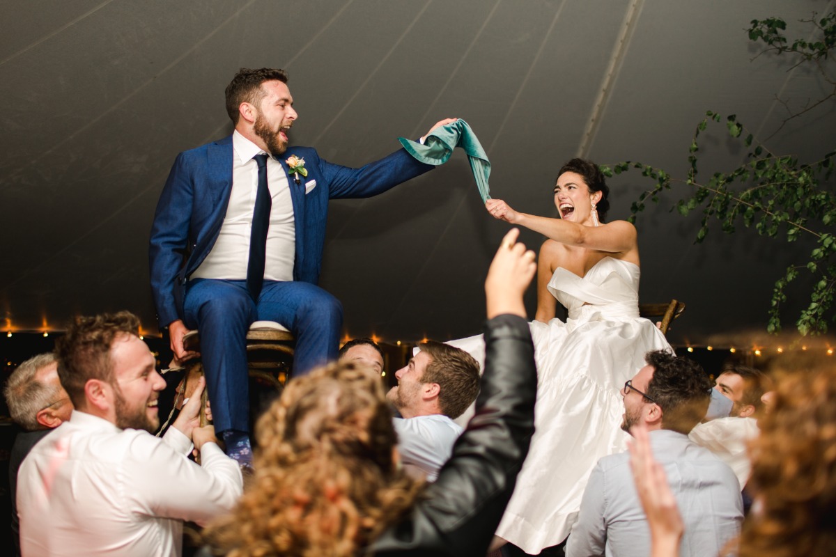 Bride and groom in the air on chairs during reception dance