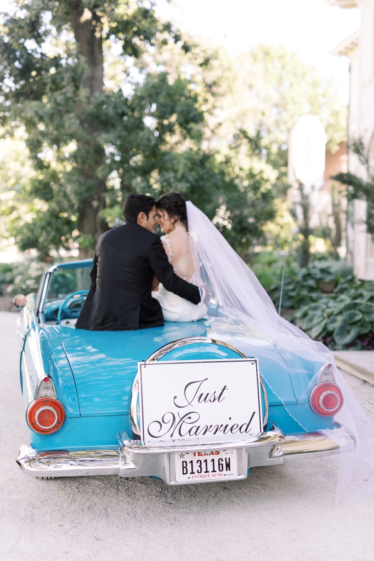 Bride and groom on car with just married sign