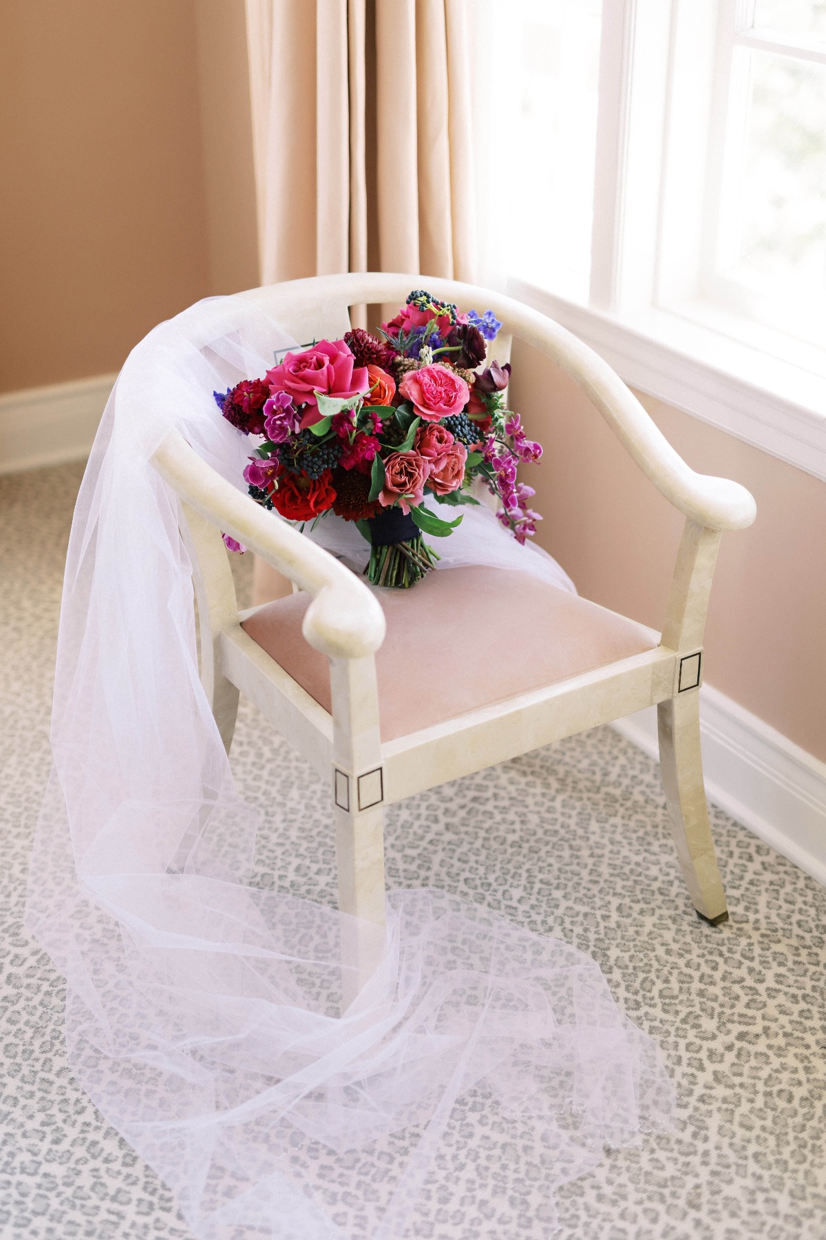 Veil draped over chair that included bouquet leaning on chair