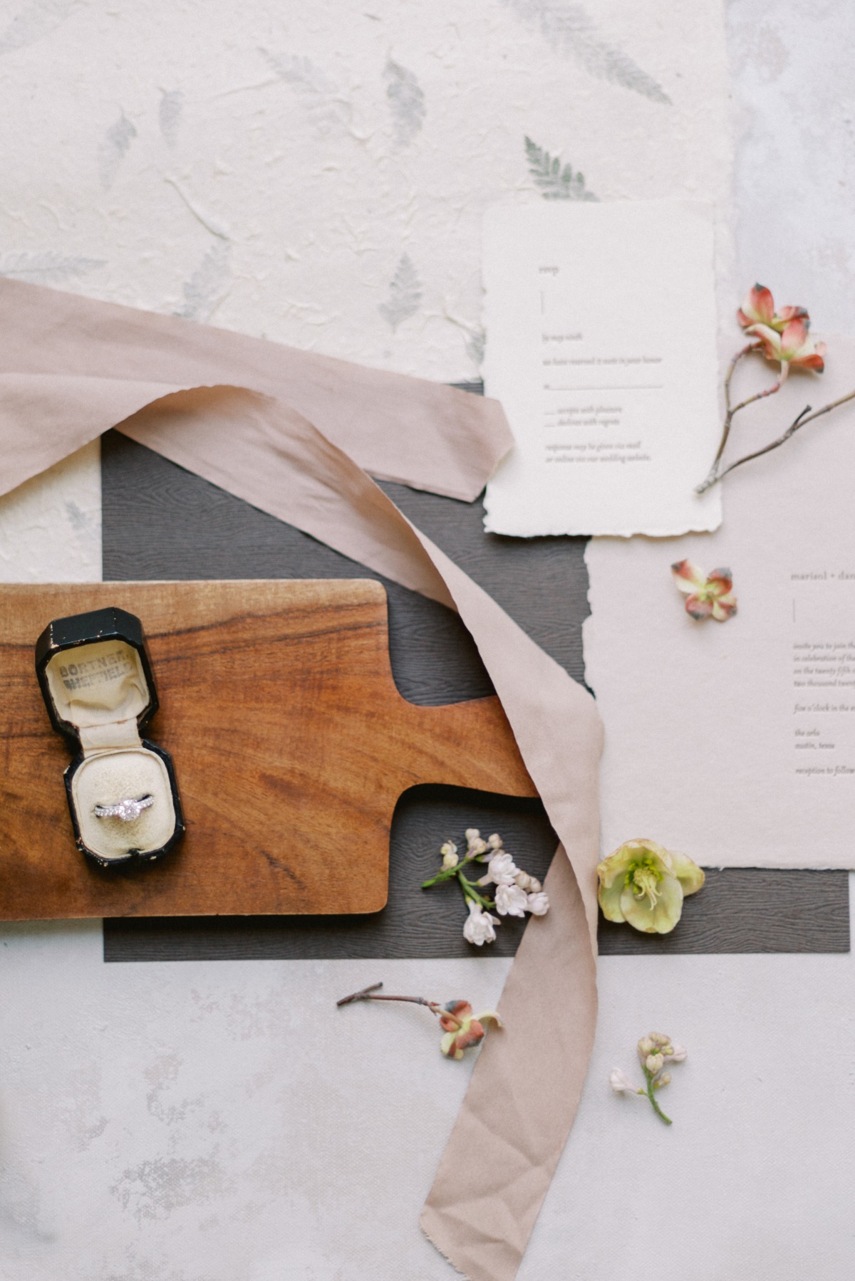 Aerial view of cutting board with engagement ring and menus