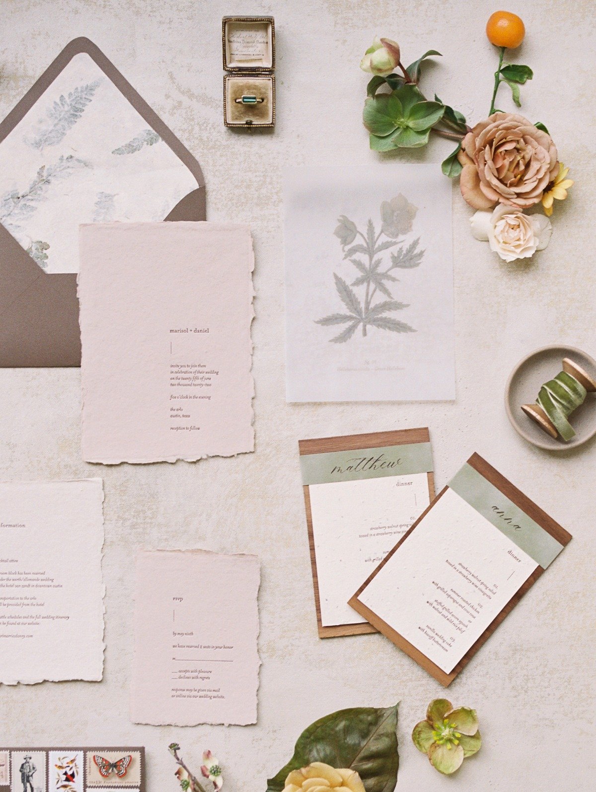 Aerial view of menus, invitations, ring, velvet, and flowers