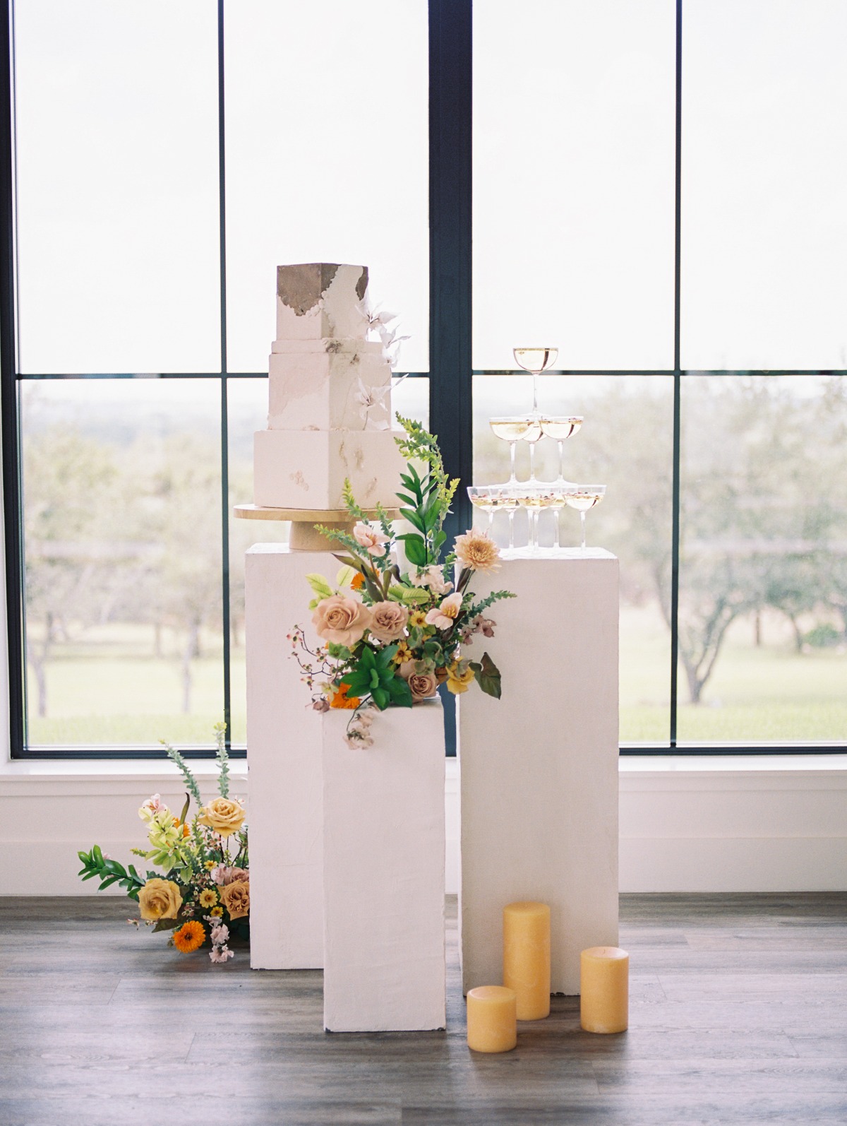 Wedding cake, floral arrangement and mini champagne tower on columns
