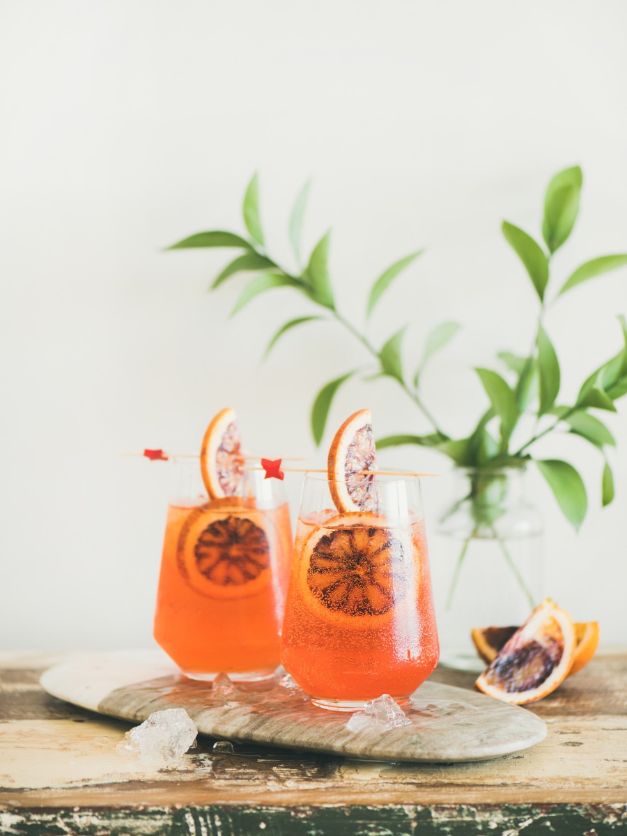 Two blood orange cocktails with ice and garnish