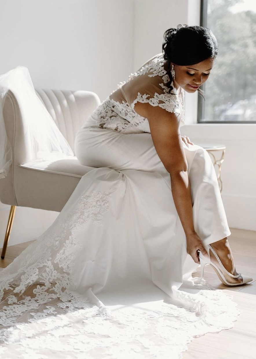 bride with updo putting on shoes