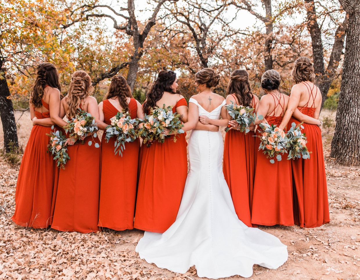 bridal party with bridesmaids in orange dresses