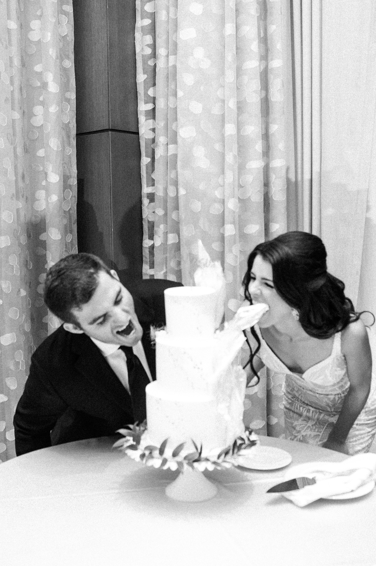 Bride and groom pretending to eat cake 