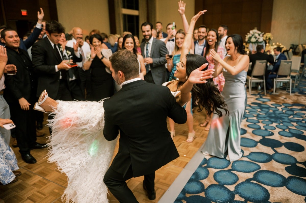 Groom carrying bride to the dance floor 