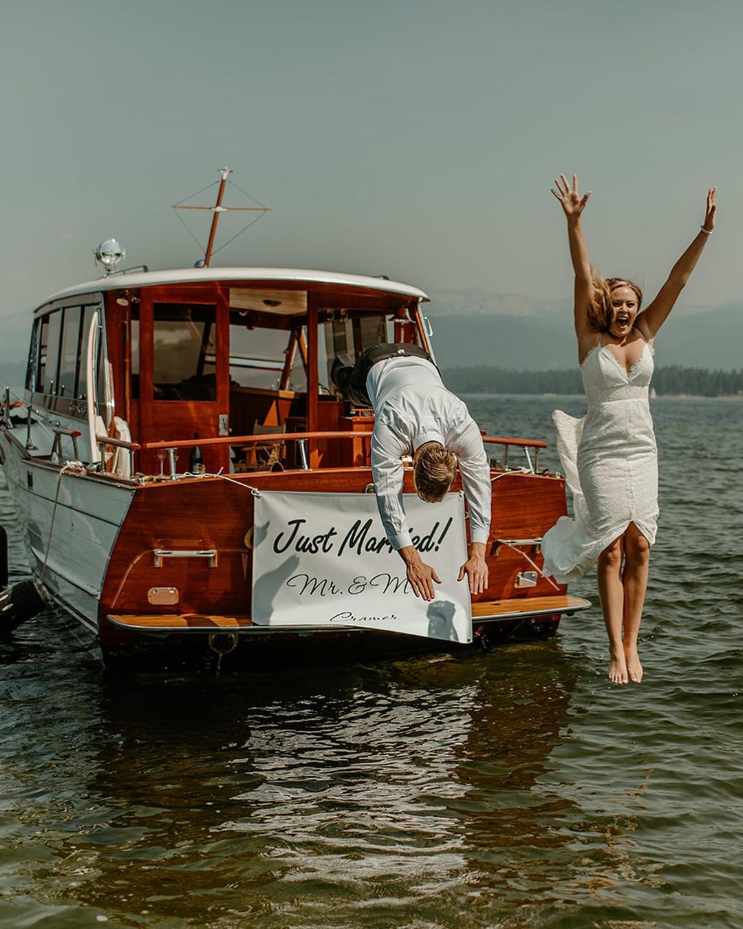 Newlyweds joyfully jumping off boat after wedding ceremony