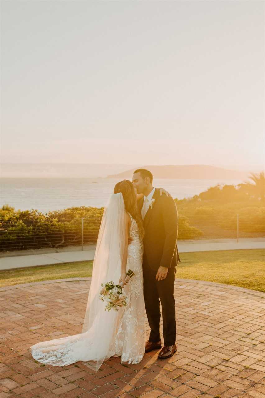 Bride and groom sharing a kiss at their ocean view wedding