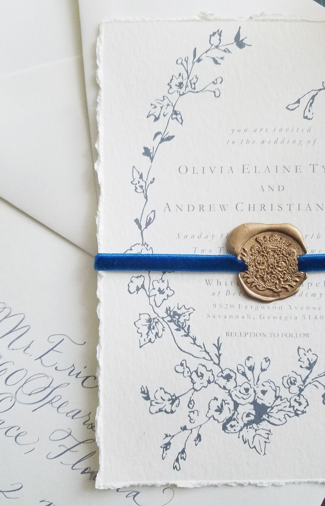 ornate gold wax seal on blue velvet ribbon for wedding invitation