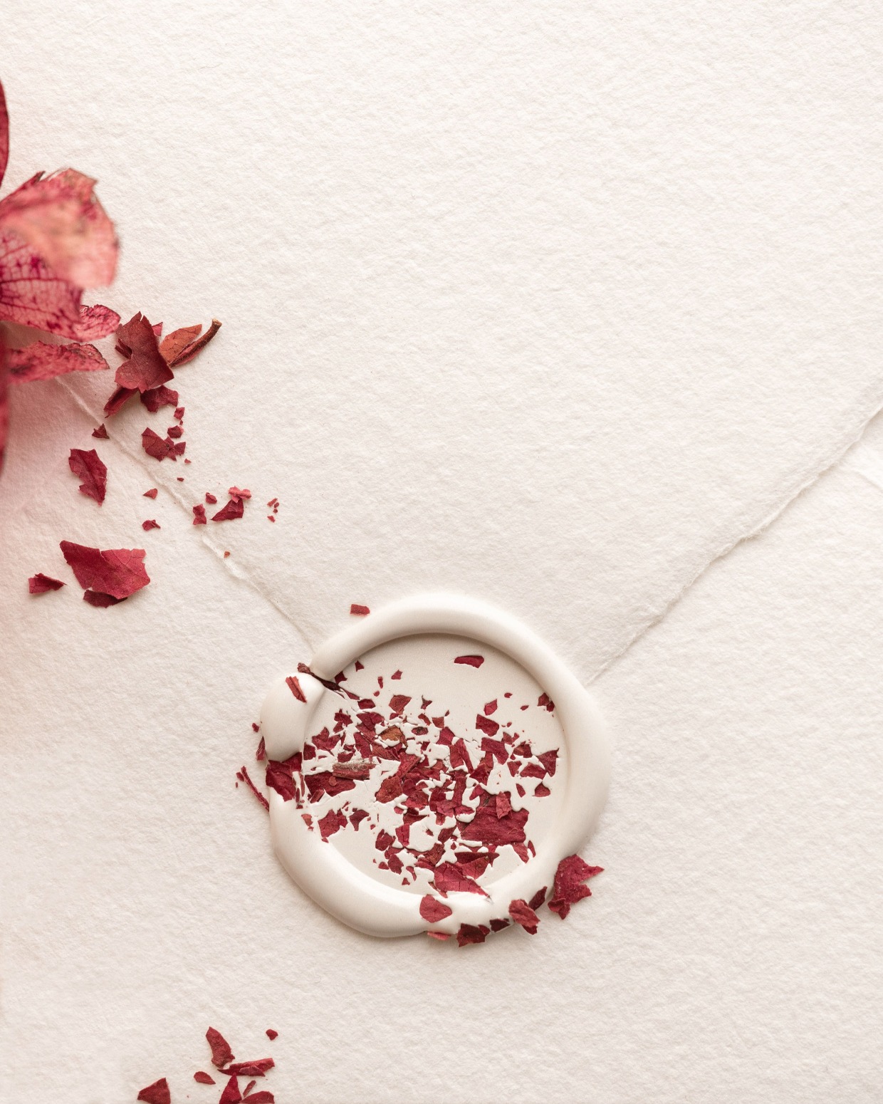 white wax seal with crushed red petals