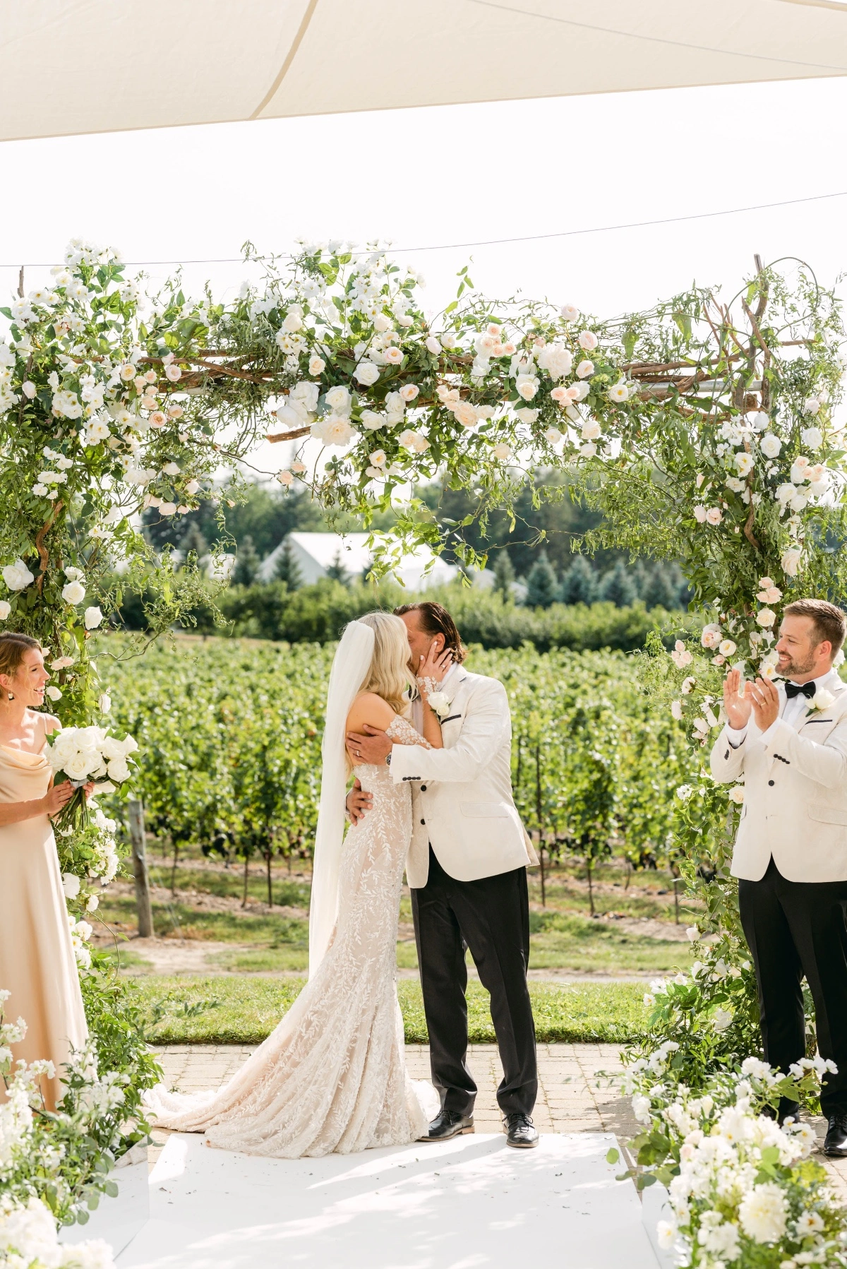 bride and groom kiss at vineyard wedding