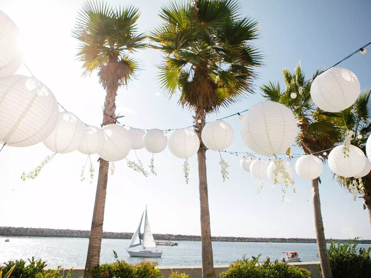 Outdoor wedding decor with white lanterns and palm trees