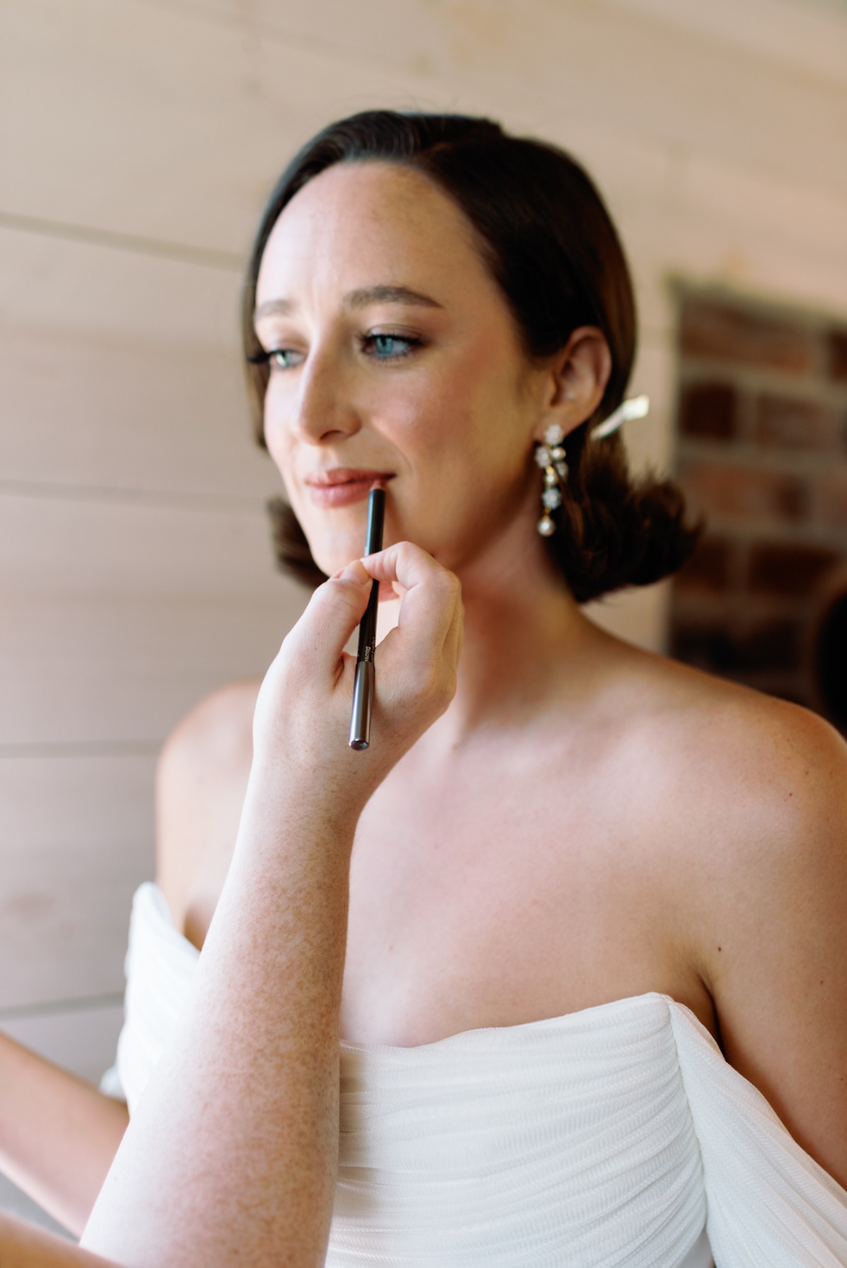 Bride putting on lip color before the ceremony