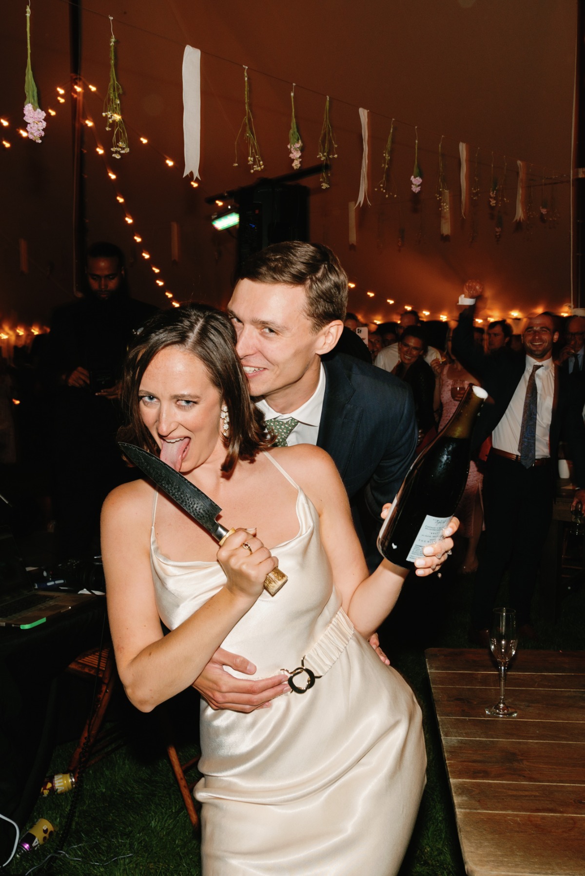 Playful bride and groom popping champagne