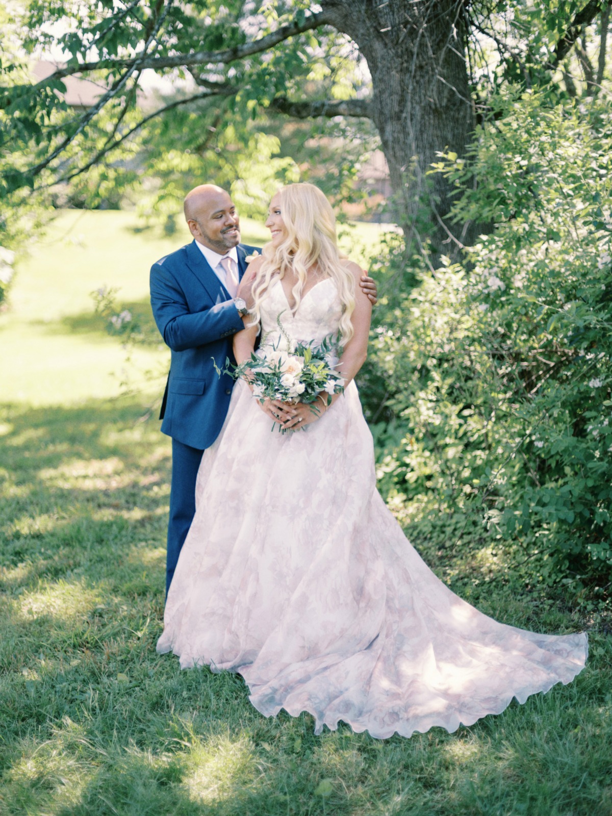 bride in blush floral dress and groom in blue suit