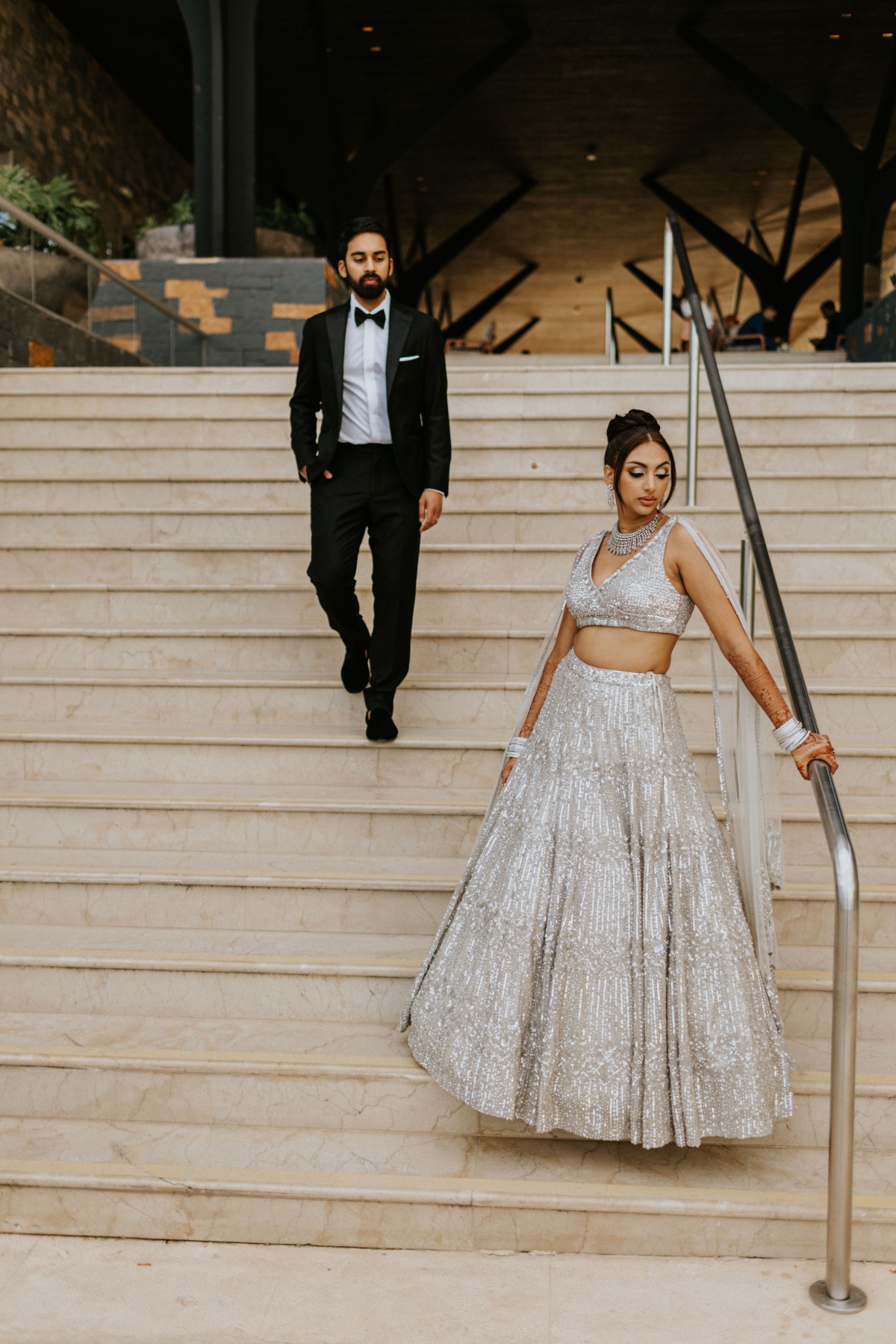 bride and groom in silver and black Indian wedding looks