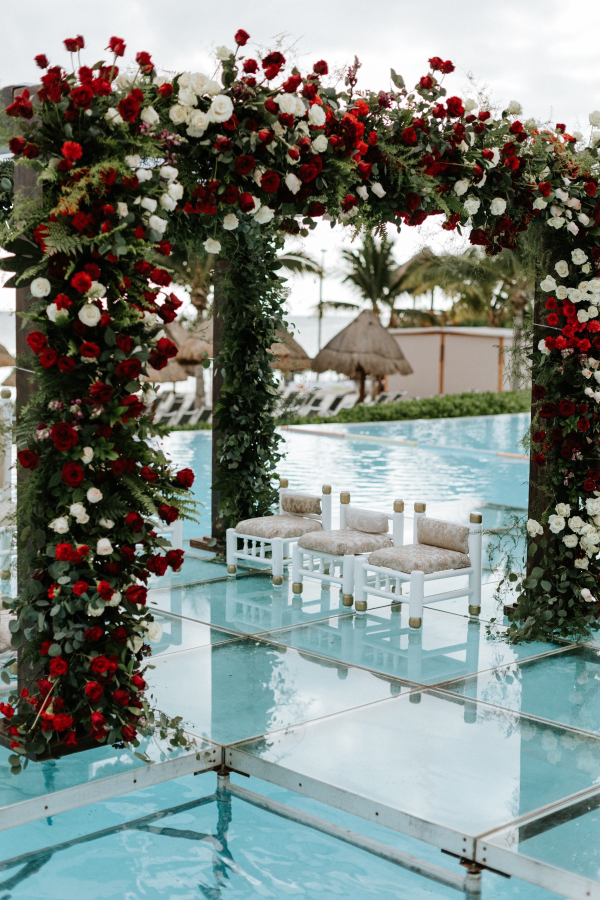 Hindu wedding ceremony with white and red roses over the pool