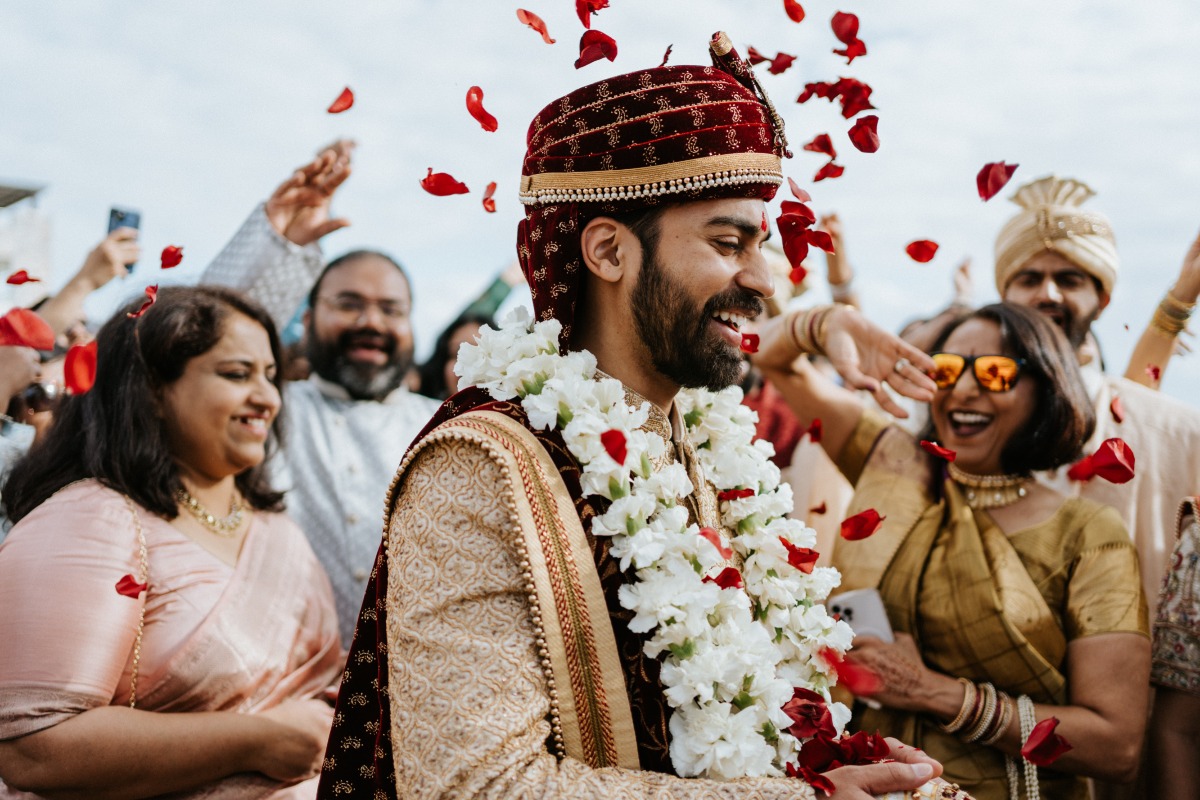groom at red and gold destination Hindu wedding ceremony