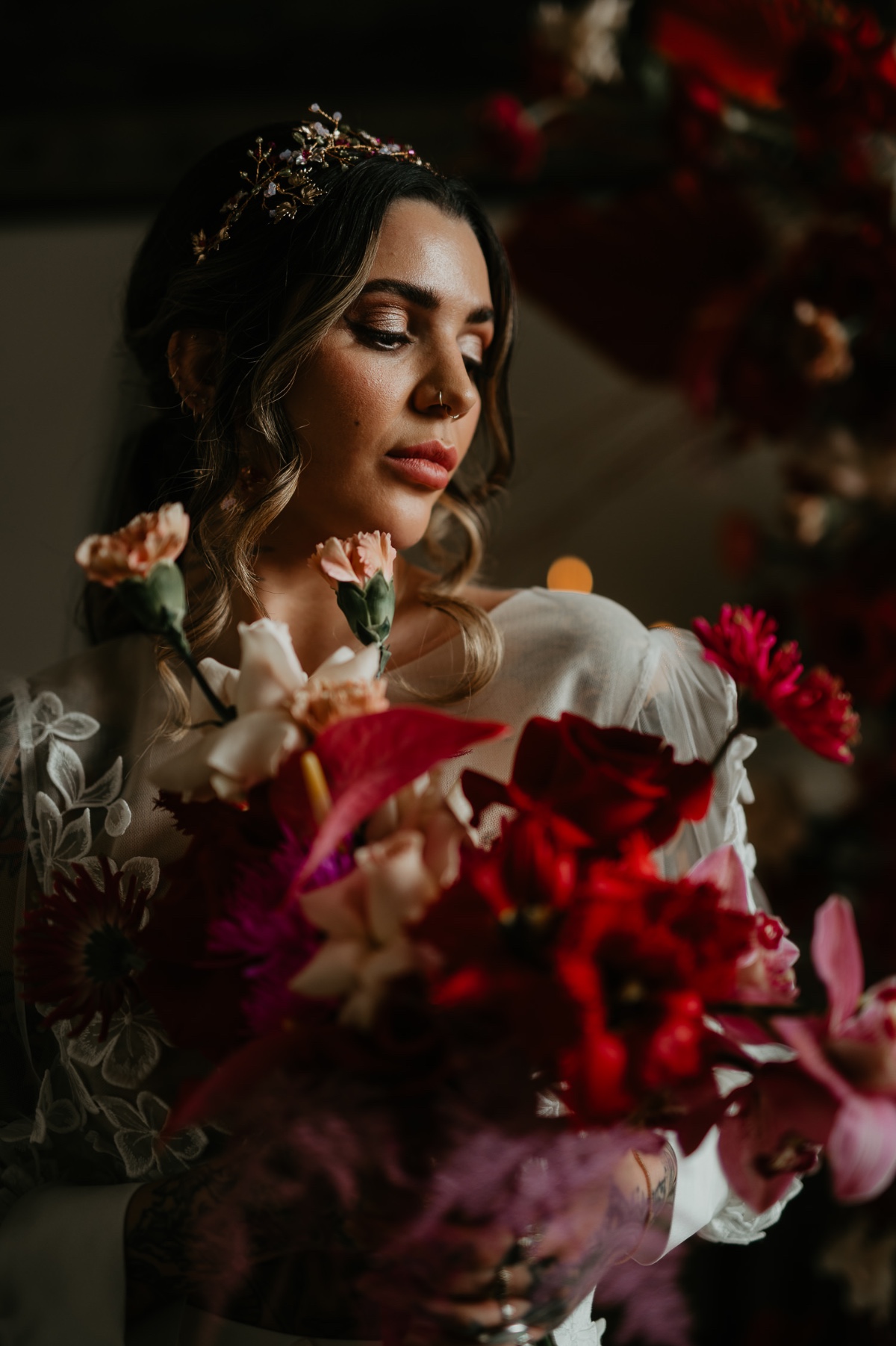 bride holds moody red and pink bouquet