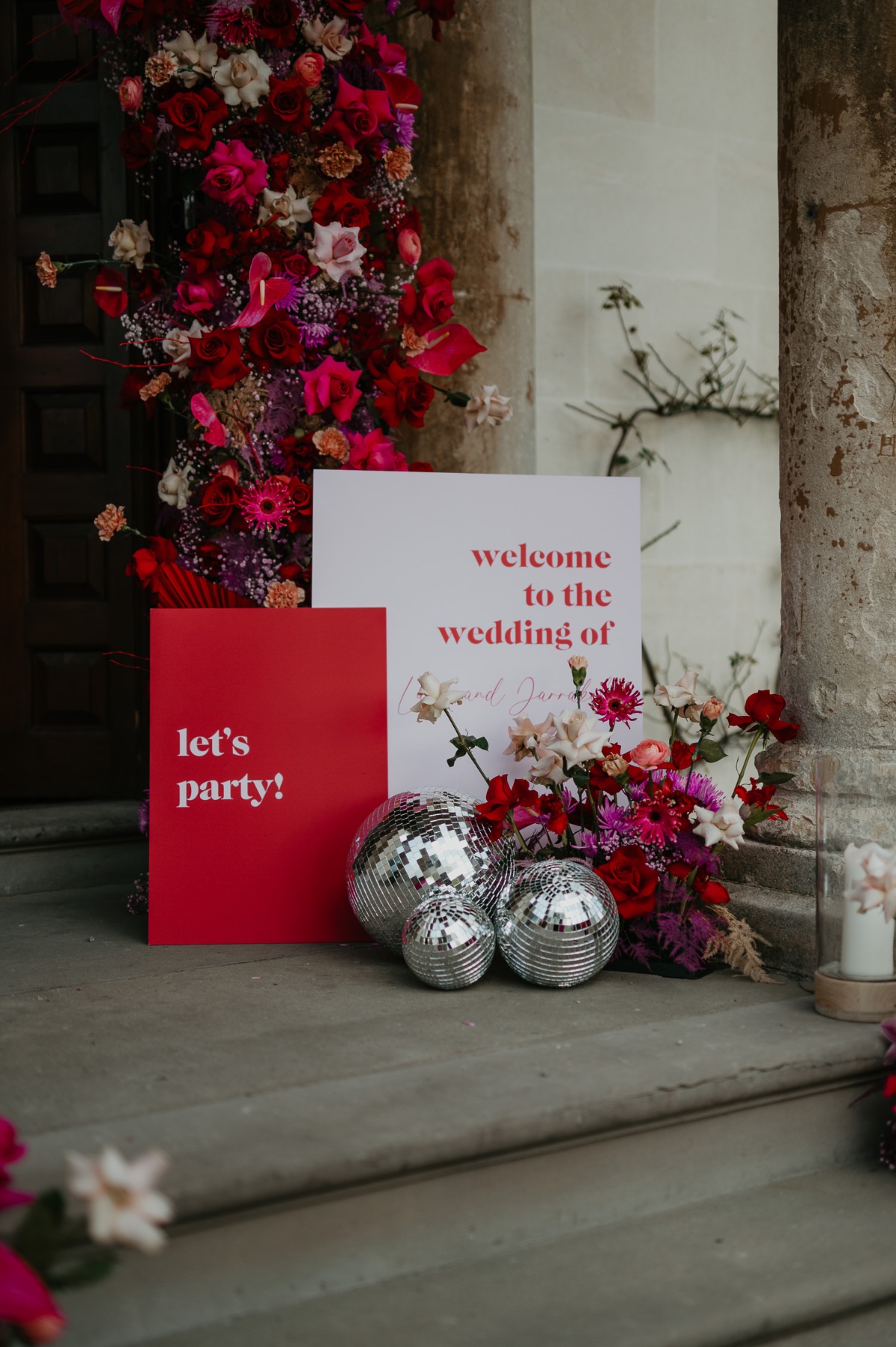 custom welcome signs at disco themed wedding with red and pink color palette