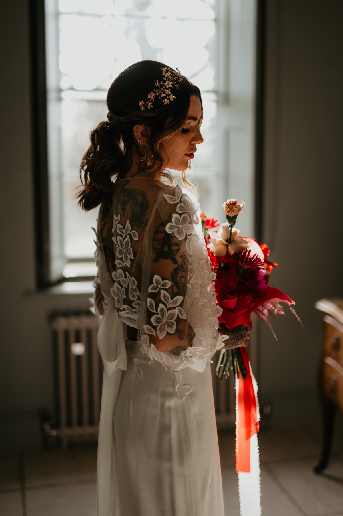 bride in blousy lace top wedding dress with silk skirt and red bouquet