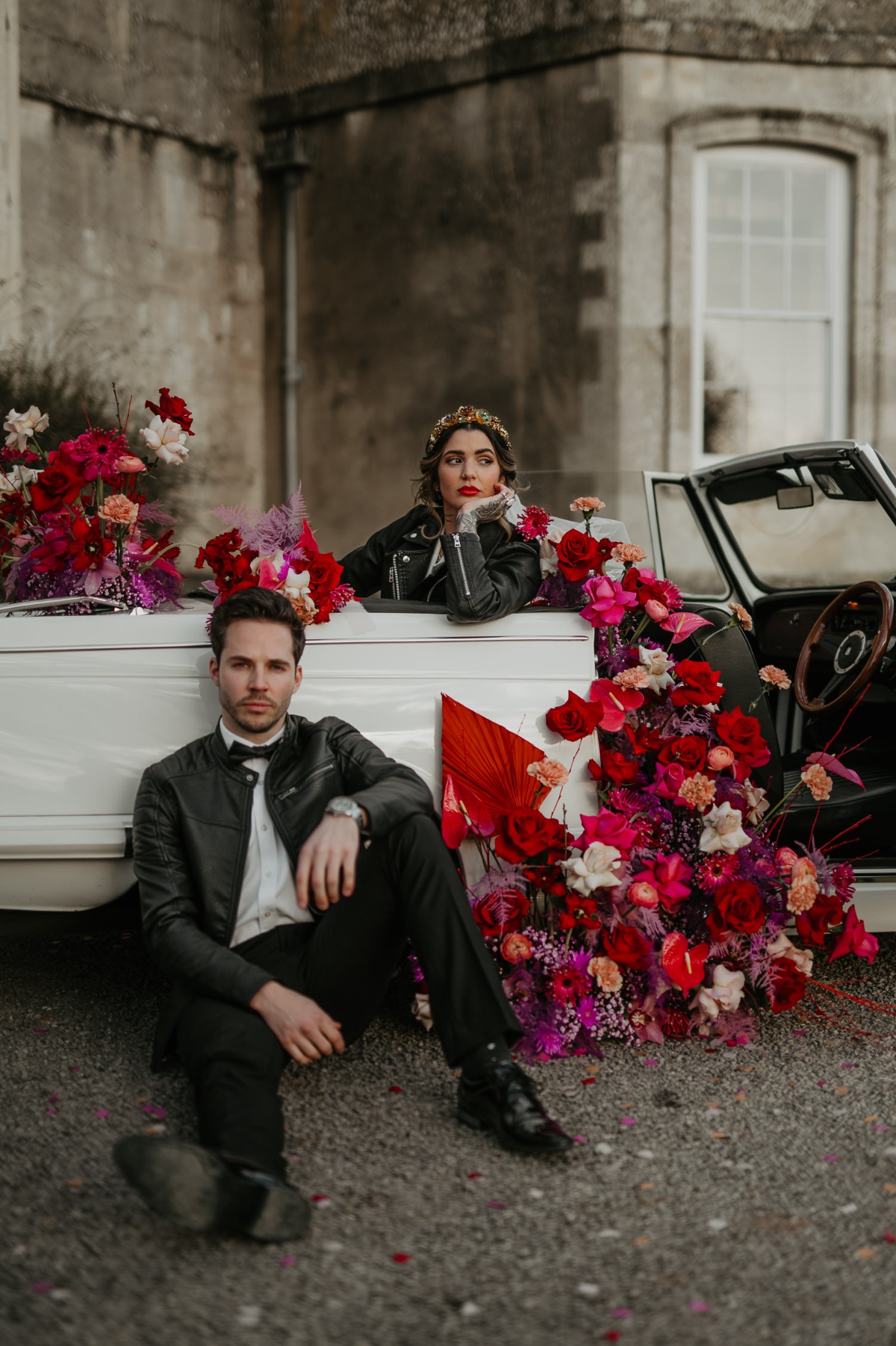 bride and groom pose with vintage car and floral installation