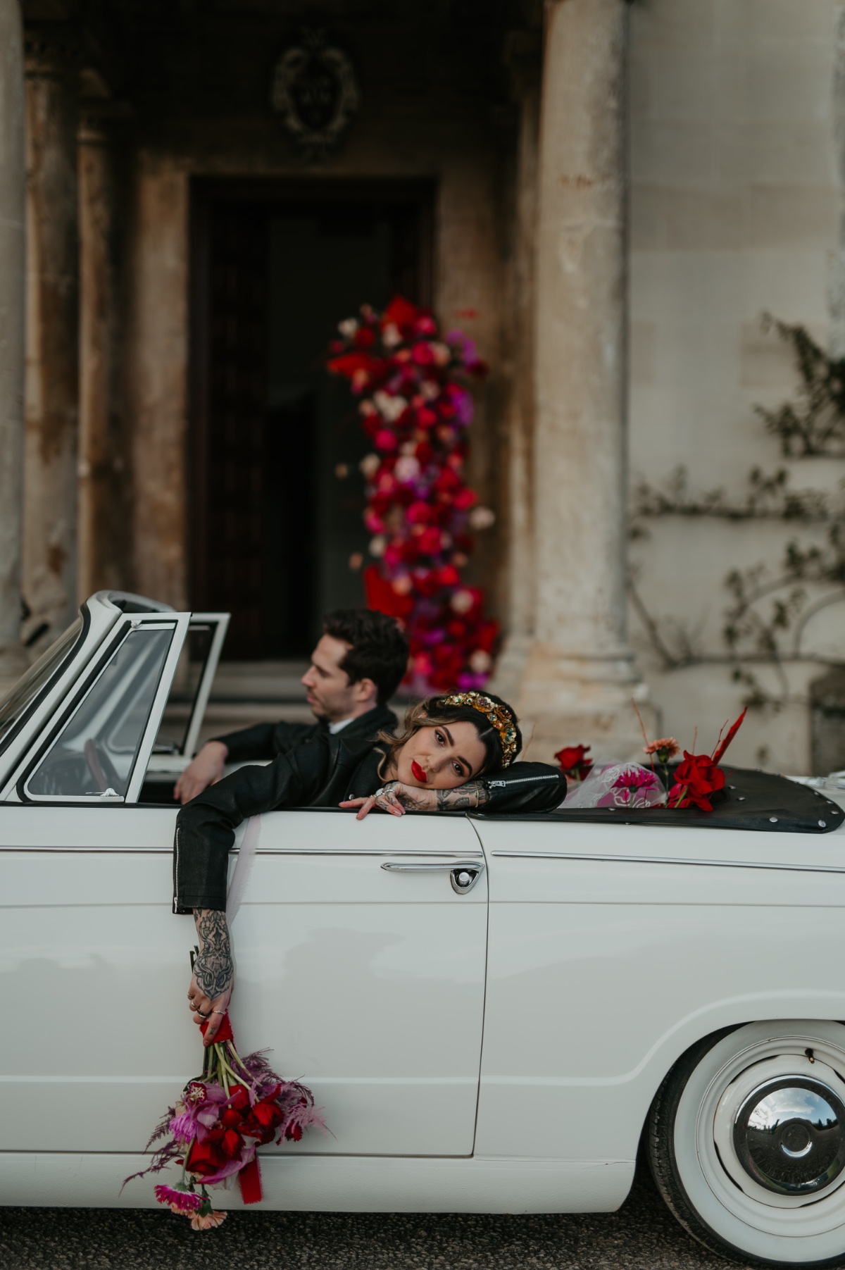 bride and groom in leather jackets with vintage car exit look