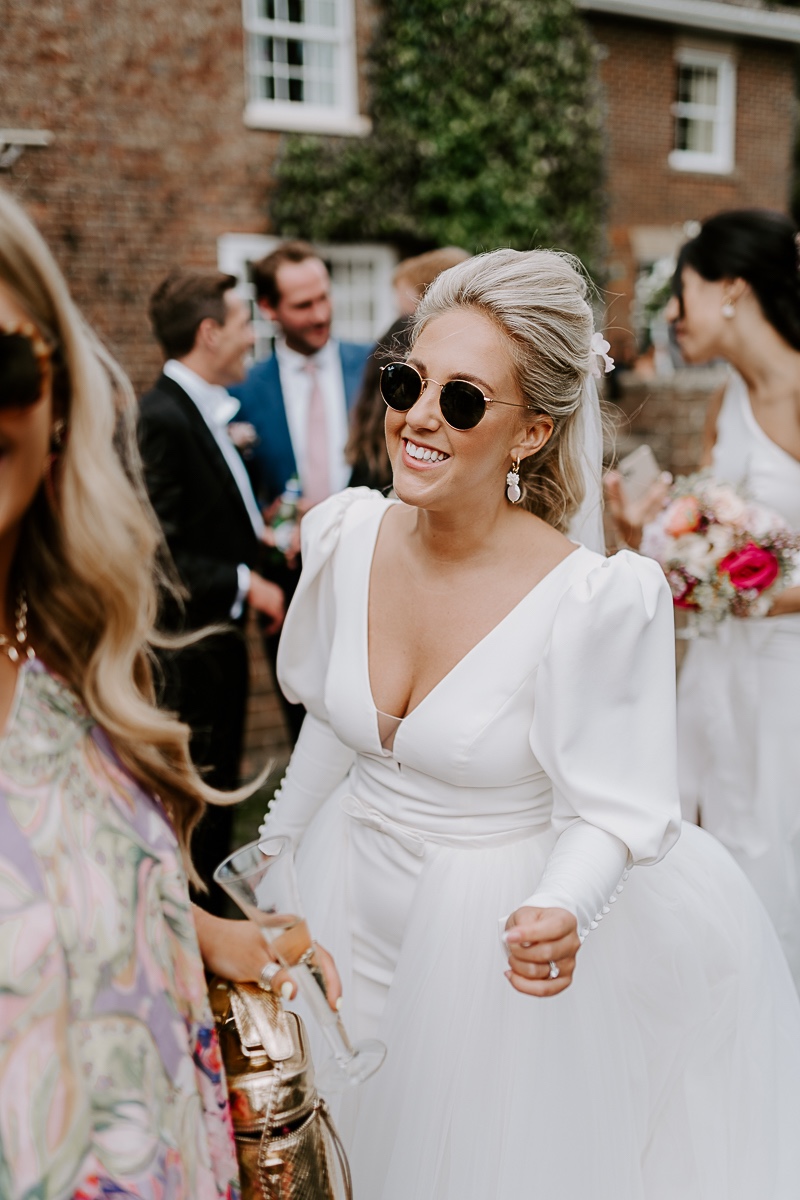 bride in long sleeve gown and sunglasses