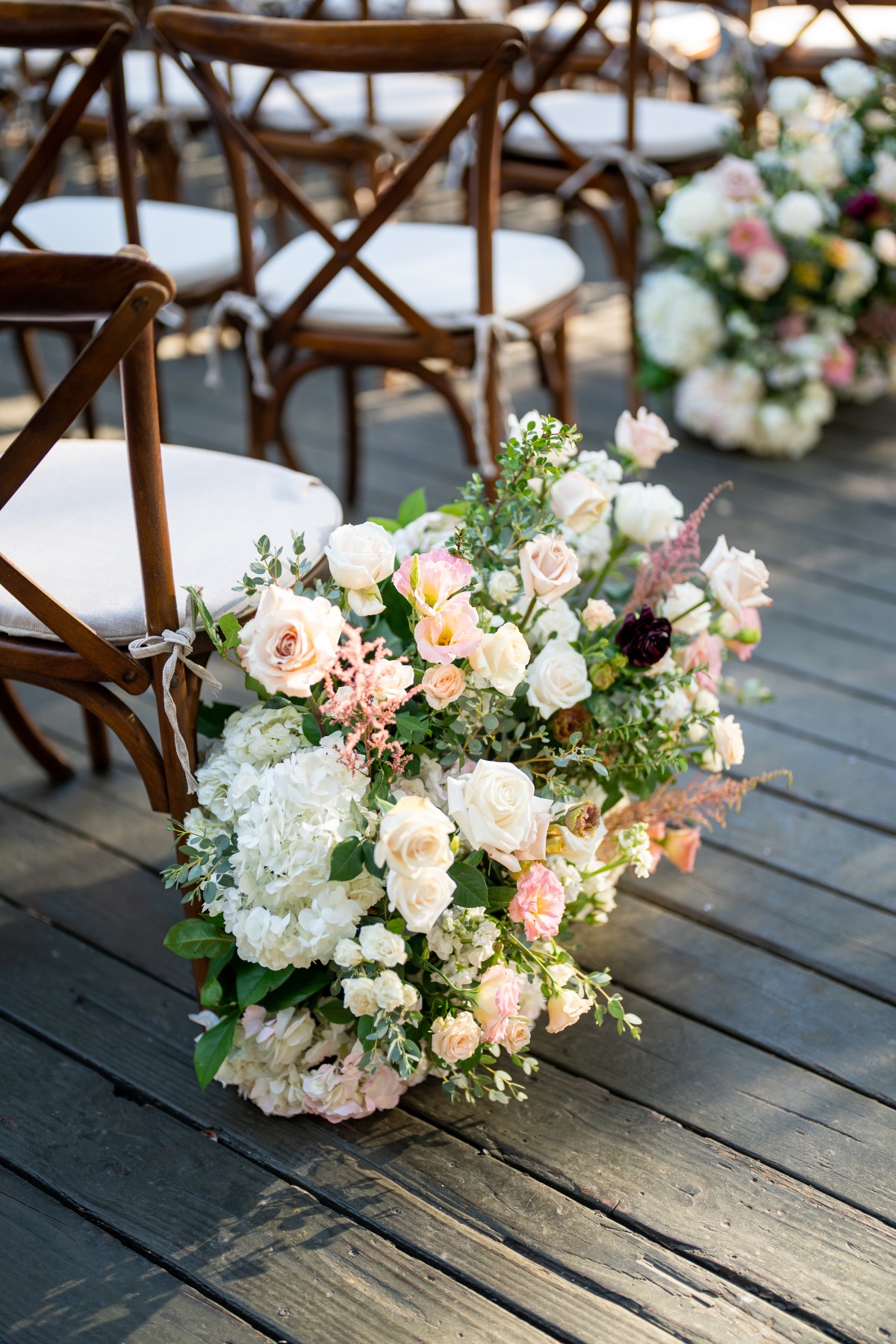 wood farm chairs and blush florals at wedding ceremony