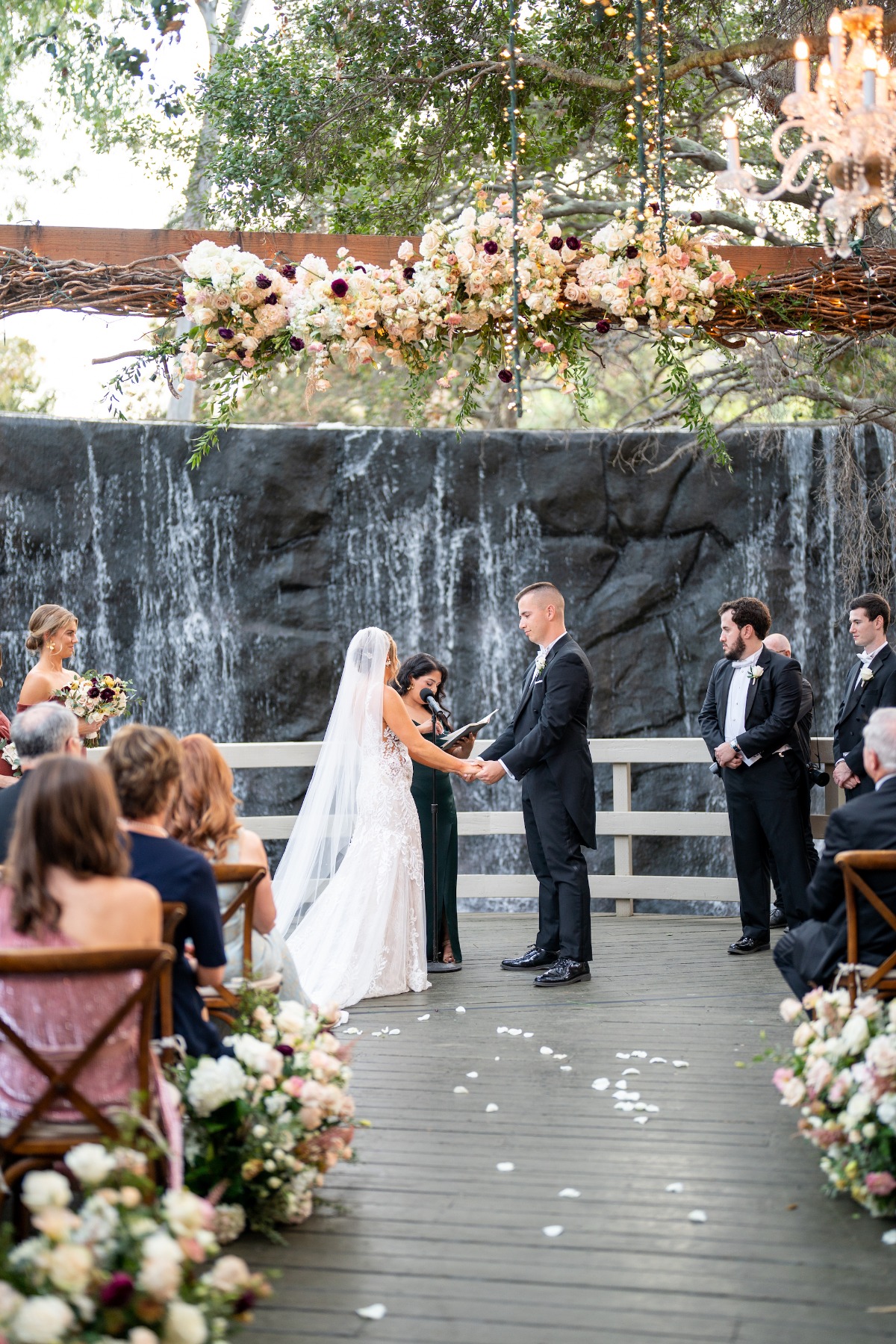 floral arch with waterfall backdrop for outdoor wedding ceremony