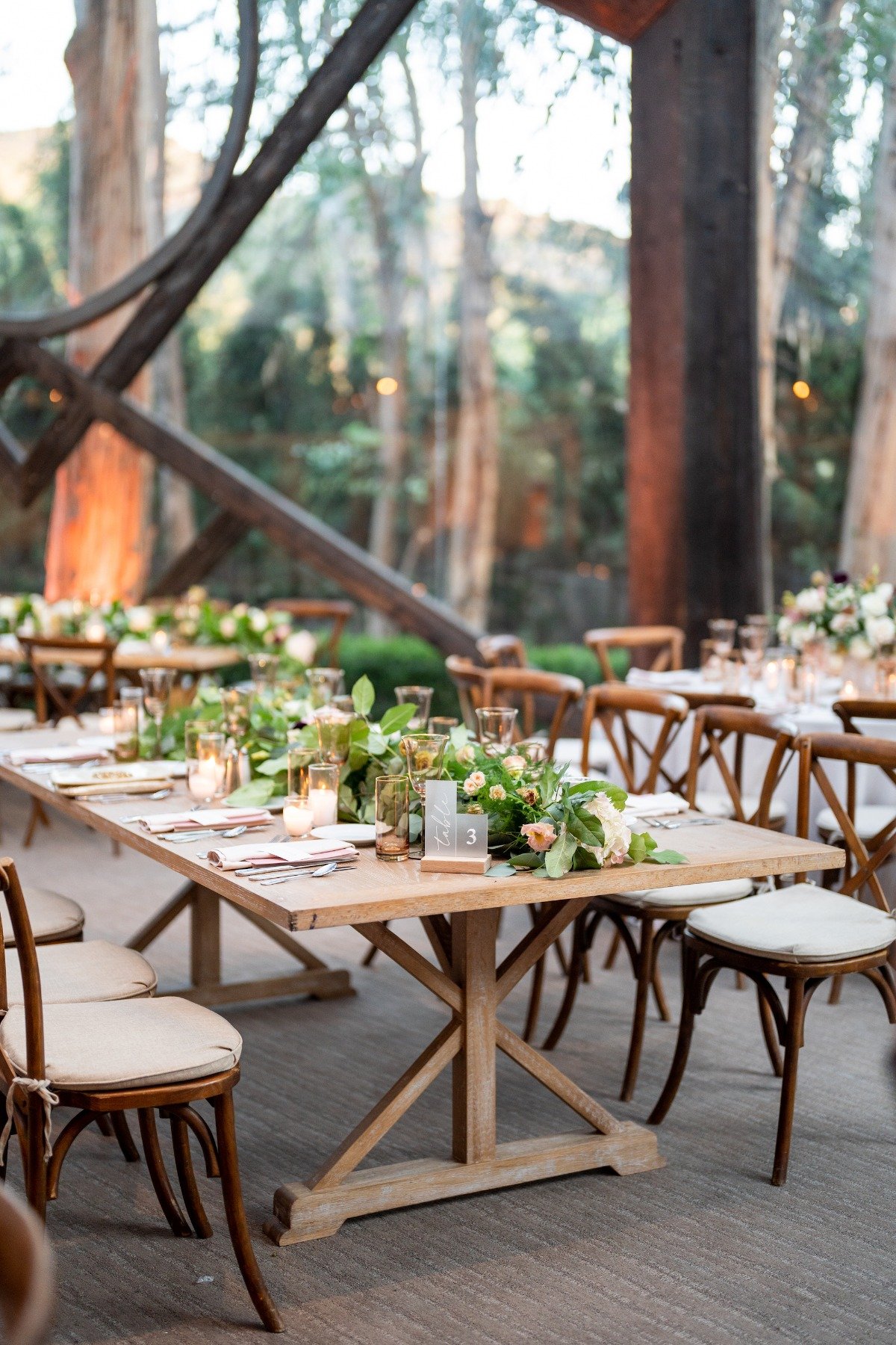 woodland wedding venue with rustic wedding design farm tables and chairs with blush accents