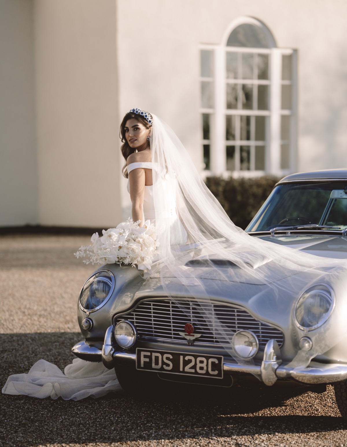 bride with white orchid bouquet and classic car