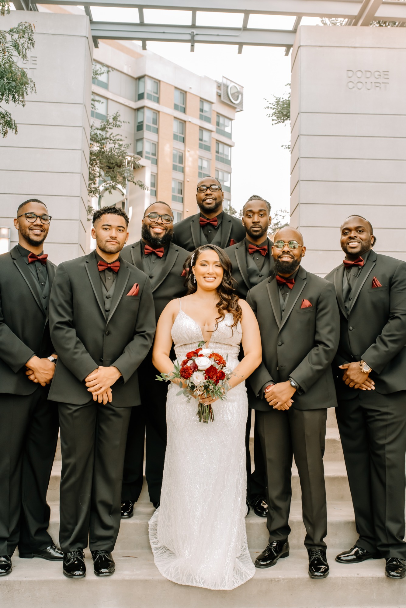 groomsmen in black suits with red bow ties