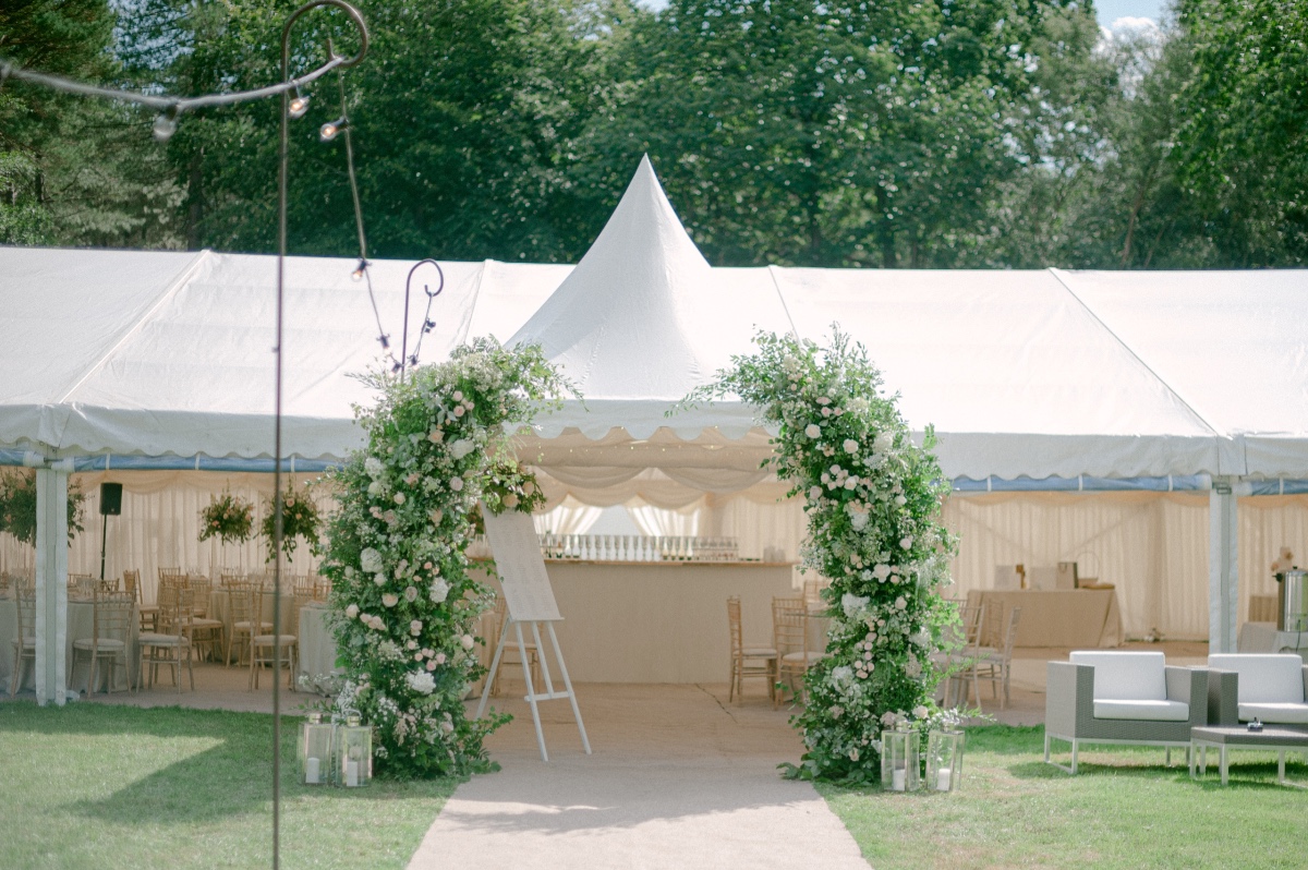 tent wedding reception with floral arch at entrance