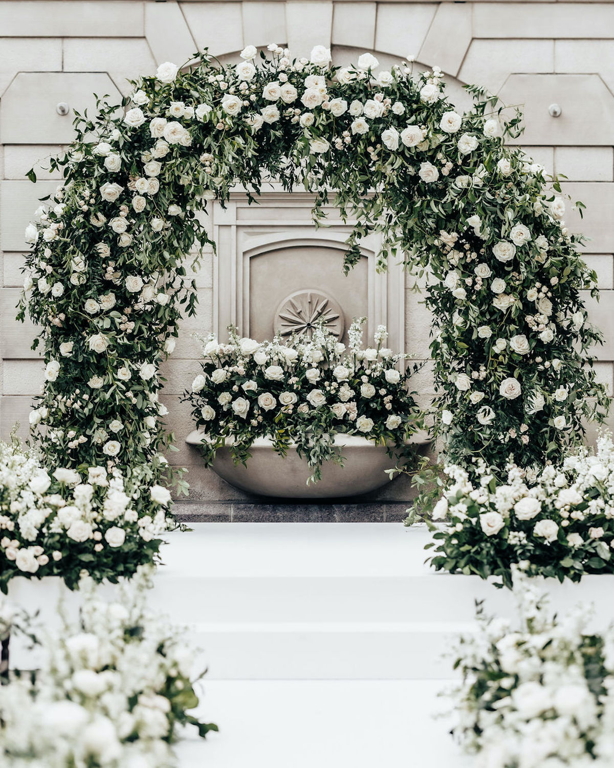 large white rose and greenery wedding arch