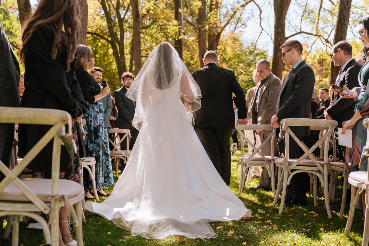 Bride walking aisle at outdoor ceremony
