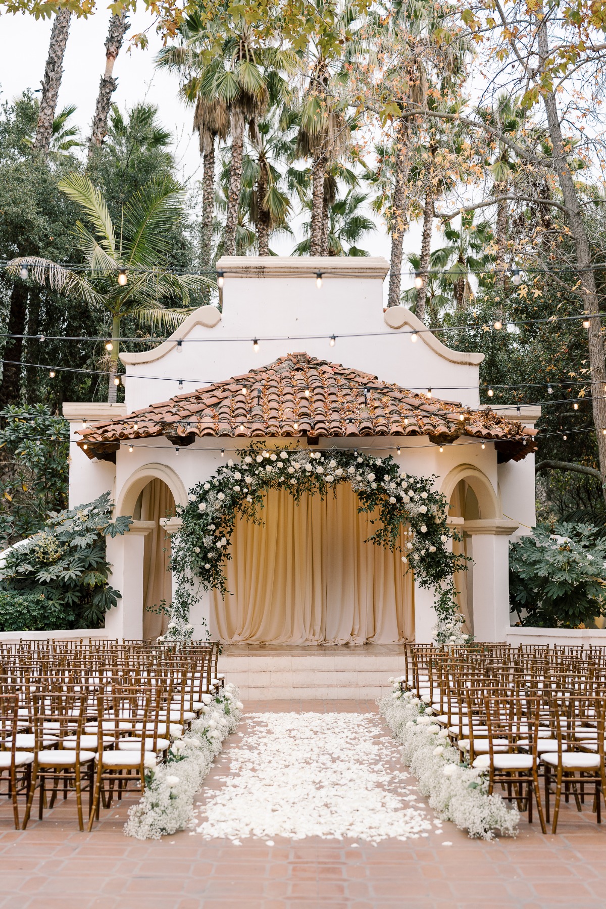 white and greenery ceremony arches