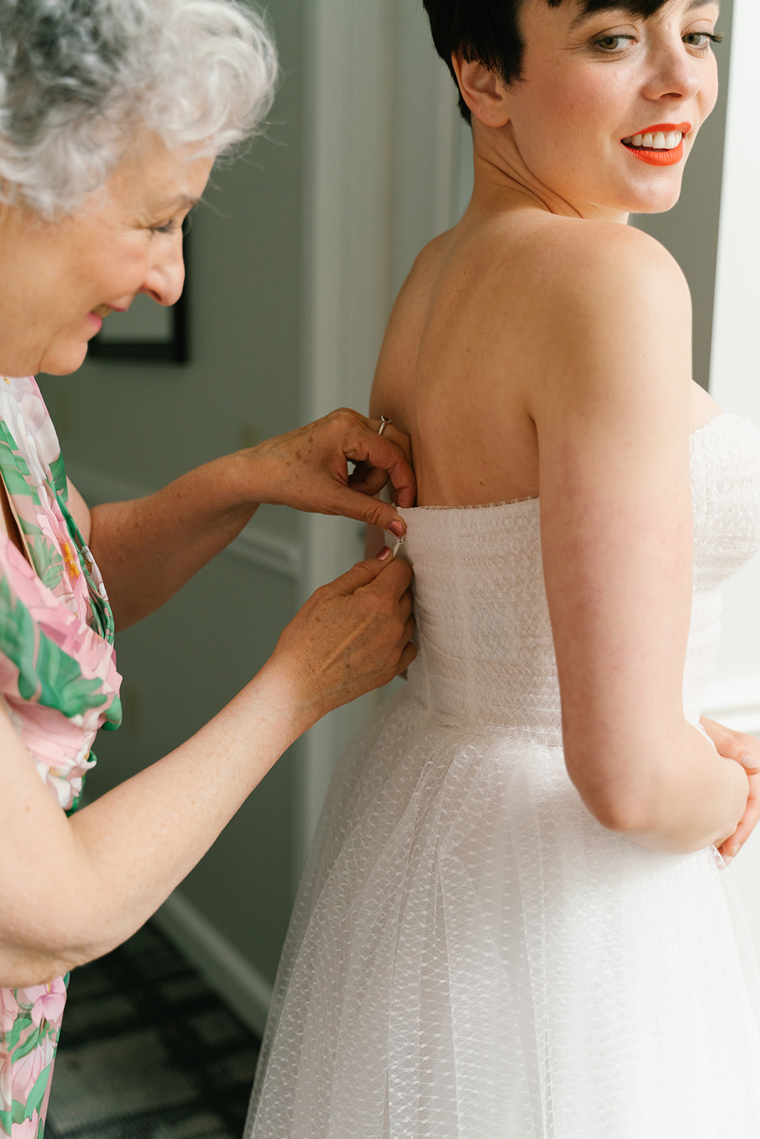 Grandma helps bride into vintage dress