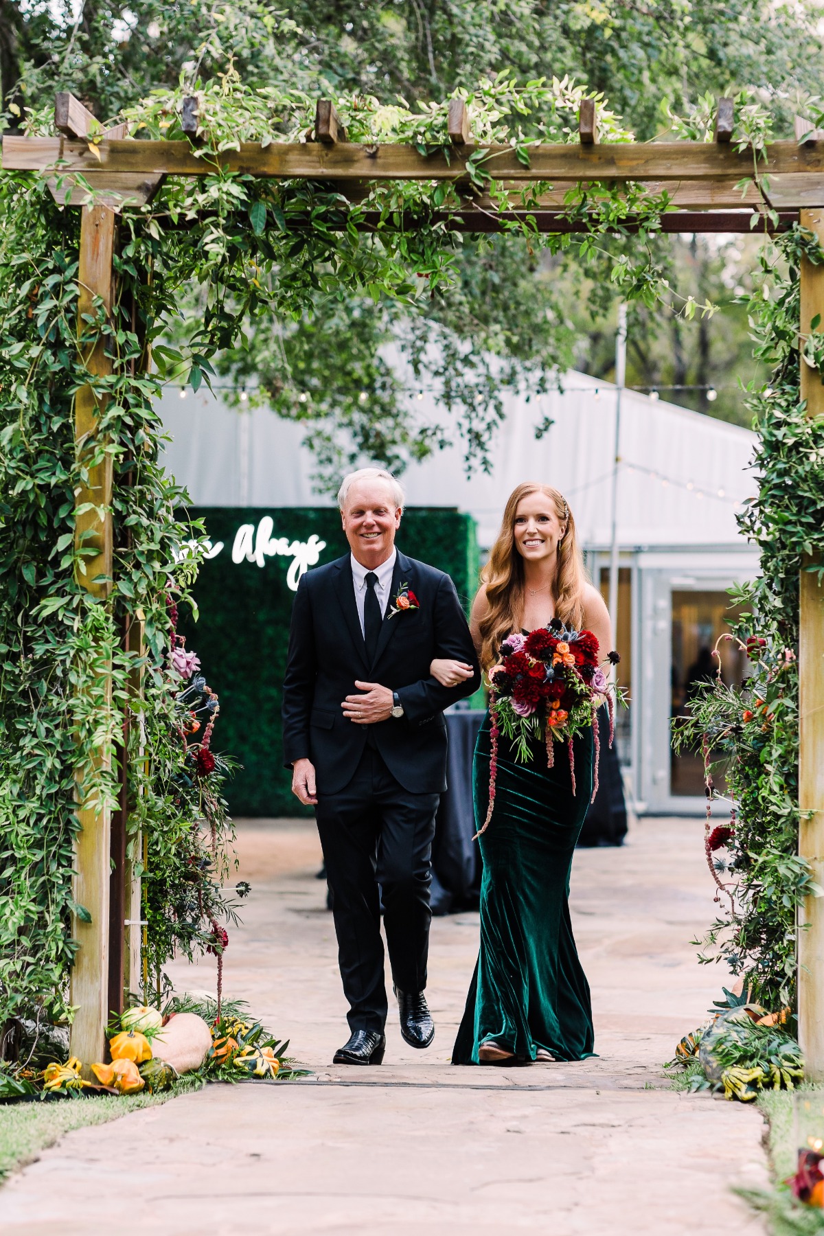Bride walking down floral greenery aisle