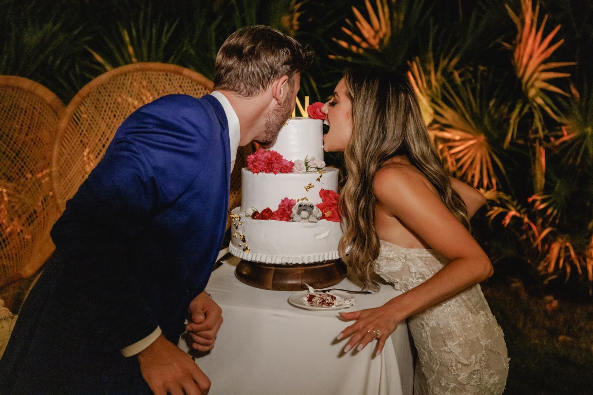 Bride and groom biting cake 