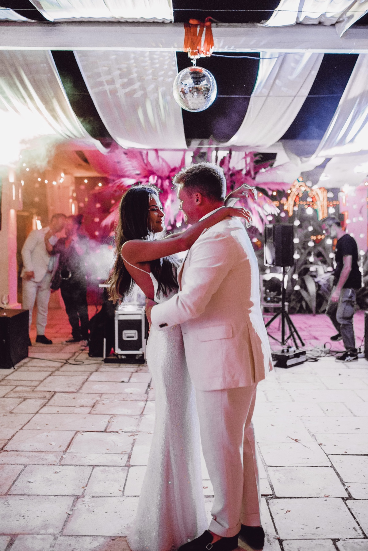 Bride and groom dancing at colorful neon reception 