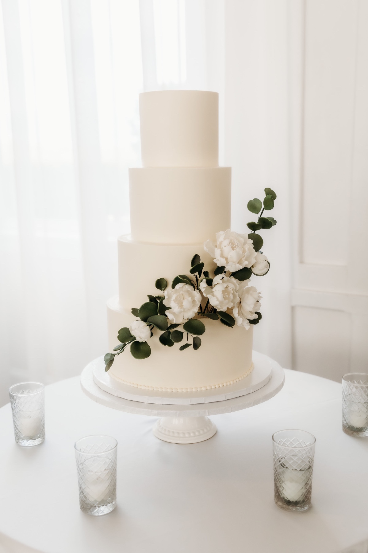 white flower and greenery wedding cake