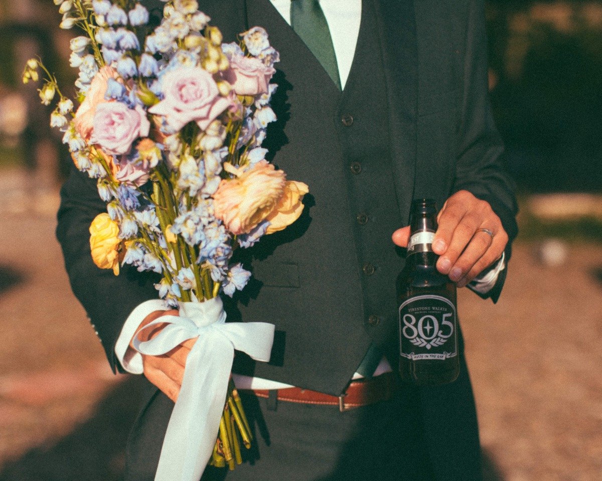 groom holding bride bouquet