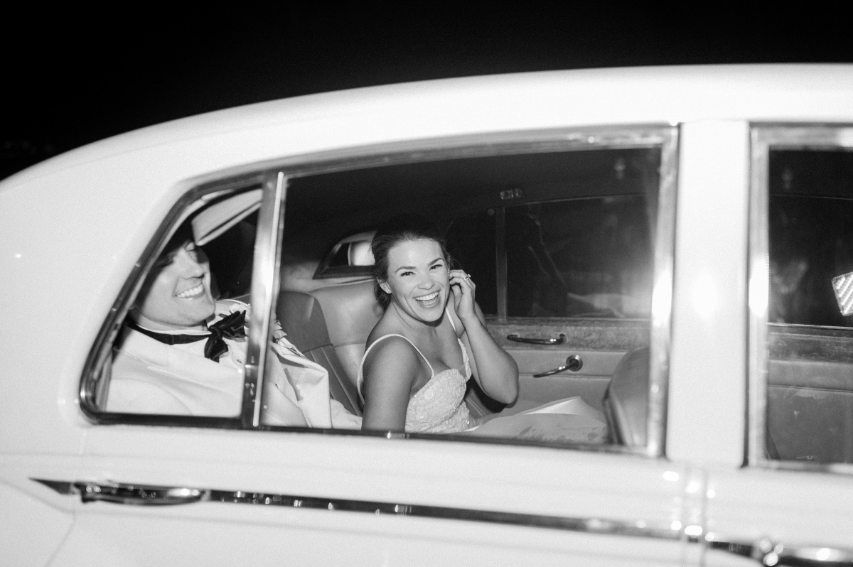 newlyweds in vintage getaway car