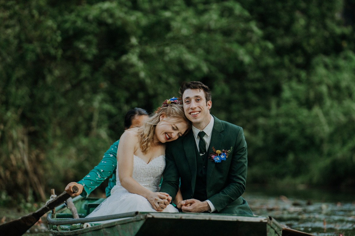 Tender wedding couple in rowboat
